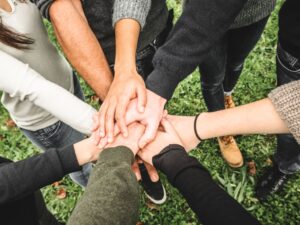 people holding hands together volunteering Paul Harris Fellowship